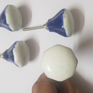Peut inclure: Quatre boutons de porte en céramique, deux sont blancs avec des accents bleus et deux sont blancs unis. Les boutons ont une vis au dos pour être fixés à une porte de placard.