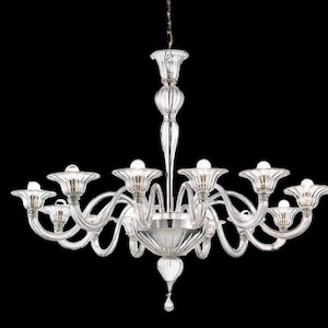 May include: A clear glass chandelier with multiple arms and a central, teardrop-shaped pendant. The chandelier has a traditional design with a classic, elegant look.