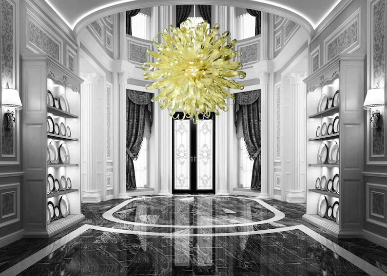 May include: A large, yellow glass chandelier hangs from the ceiling of a grand, white entryway with black and white marble floors. The chandelier has a unique, organic shape with many curved arms.