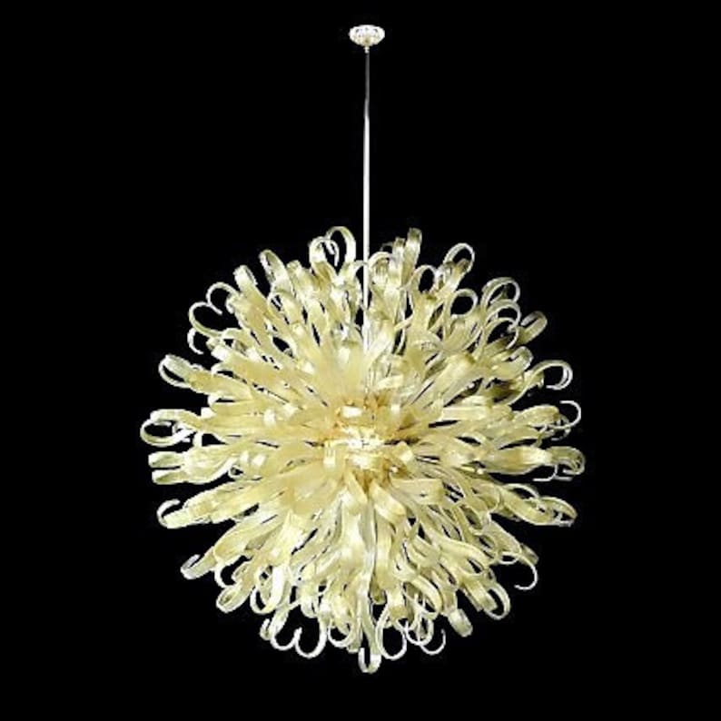 May include: A large, round, gold-colored chandelier with many curved glass pieces. The chandelier is suspended from a single chain.