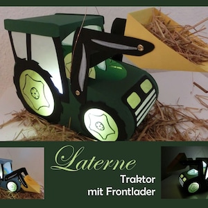 Op de afbeelding: Een groene tractorvormige lantaarn met een voorlader, van binnenuit verlicht. De wielen en ramen gloeien, en de voorlader bevat stro. De tekst "Laterne Traktor mit Frontlader" is zichtbaar.