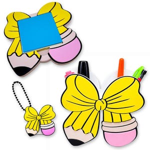 May include: A set of yellow bow-shaped pencil holders and a keychain. The pencil holders have a pink eraser and a black pencil tip. One holder has a blue sticky note pad. The other holder contains pens and markers.