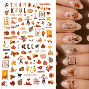 May include: A sheet of adhesive nail decals featuring autumn-themed illustrations including pumpkins, scarecrows, foxes, owls, maple leaves, and text such as thankful, grateful, and fall, alongside fingernails decorated with these specific stickers.