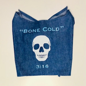 May include: A blue denim bandana with a white skull and crossbones graphic and the text "BONE COLD" and "3:16".