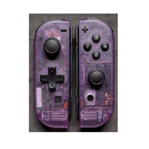 May include: A pair of purple transparent Nintendo Switch Joy-Con controllers with black buttons. The controllers are separated and show the internal components.