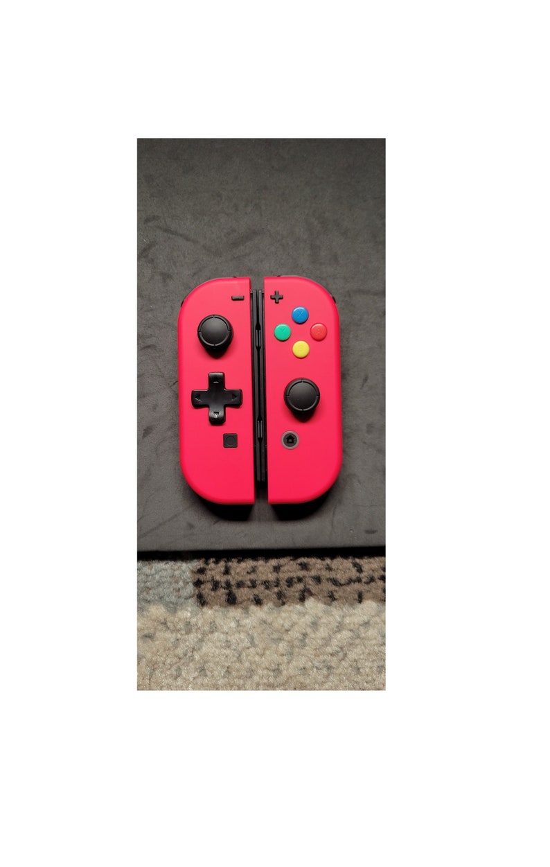 May include: A bright red Nintendo Switch Joy-Con controller with black buttons. The controller is in the open position, showing the two halves.