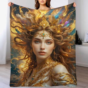 May include: A plush blanket featuring a digital art portrait of a woman with long, flowing hair and a golden crown. The artwork has a celestial theme with gold, blue, and yellow hues, creating a dreamy and ethereal aesthetic.