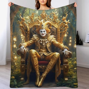 May include: A blanket featuring a golden throne with a seated clown in a gold suit and makeup. The clown is in a forest setting with soft lighting. The blanket is held up by a person.