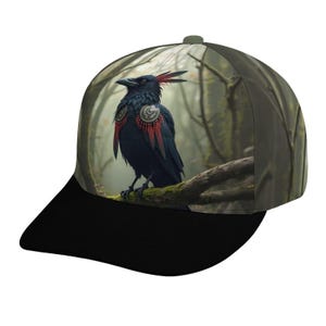 May include: A black baseball cap featuring a detailed illustration of a raven perched on a mossy branch. The raven has red and black plumage and is set against a misty forest backdrop. The cap has a black brim and a green crown.