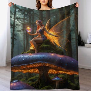 May include: A fantasy-themed blanket featuring a fairy sitting on a giant mushroom in a forest. The fairy has orange wings and is holding a glowing orb. The mushroom is purple with an orange underside, and the forest is dark and mysterious.