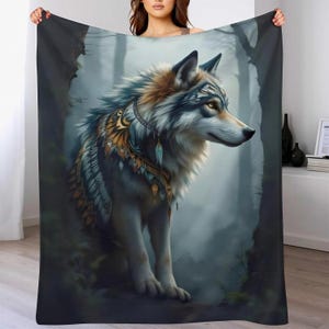 Peut inclure: Un plaid rectangulaire orné d'une illustration détaillée d'un loup au pelage gris, blanc et brun. Le loup porte des ornements décoratifs en plumes dorées et bleues autour du cou et des épaules, sur un fond de forêt brumeuse.