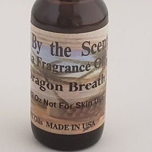 May include: A small brown glass bottle with a black cap. The label reads "By the Scent-sational Fragrance Oils Dragon Breath 2 oz Not For Skin Use SOils MADE IN USA".