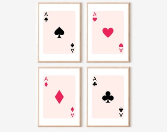 May include: Four printable art prints featuring the ace of each suit in a playing card deck. The cards are depicted in a minimalist style with a pink background and black card suits. The ace of spades, hearts, diamonds, and clubs are shown.