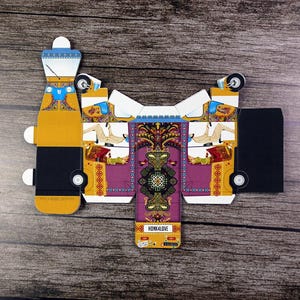 An overhead view of a flat unassembled, intricately patterned rickshaw-shaped box, emphasizing its craftsmanship.