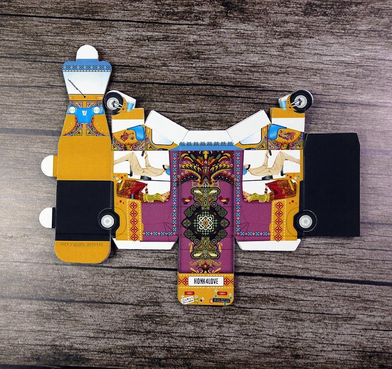 An overhead view of a flat unassembled, intricately patterned rickshaw-shaped box, emphasizing its craftsmanship.