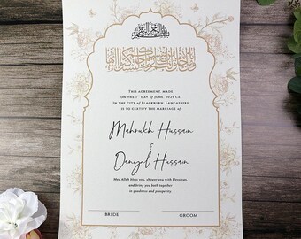Puede incluir: Invitación de boda marfil con detalles florales dorados y caligrafía árabe. El texto incluye los nombres Mahrukh Hussain y Danyal Hussain, la fecha 1 de junio de 2025 y la ciudad de Blackburn, Lancashire.