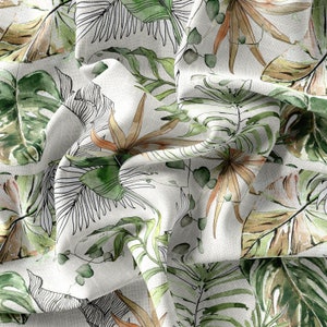 May include: White fabric with a green and brown tropical leaf pattern. The fabric is crumpled and has a textured surface.