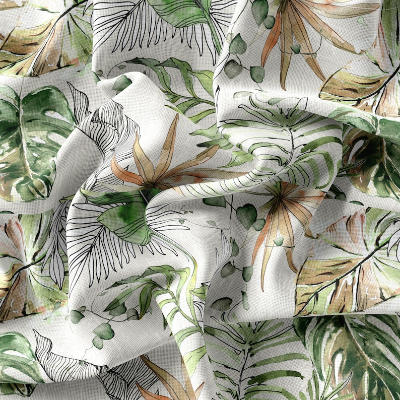 May include: White fabric with a green and brown tropical leaf pattern. The fabric is crumpled and has a textured surface.