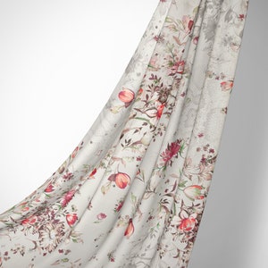 May include: A white fabric with a floral print featuring red, pink, and green flowers. The fabric is draped over a white background.