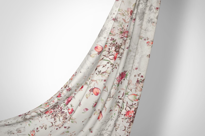 May include: A white fabric with a floral print featuring red, pink, and green flowers. The fabric is draped over a white background.