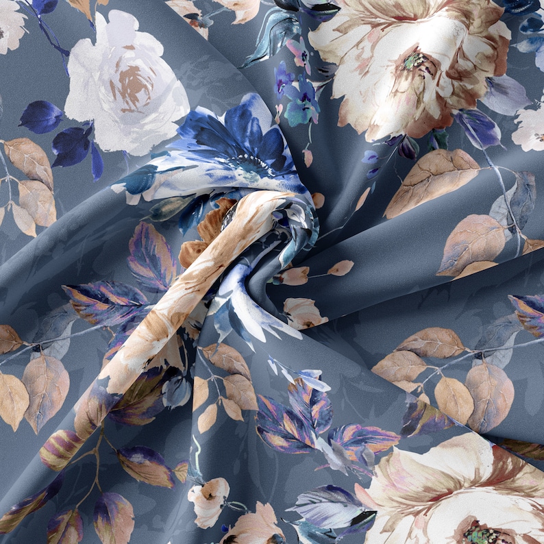 May include: A blue fabric with a floral print featuring white, brown, and blue flowers. The fabric is folded and the flowers are in focus.