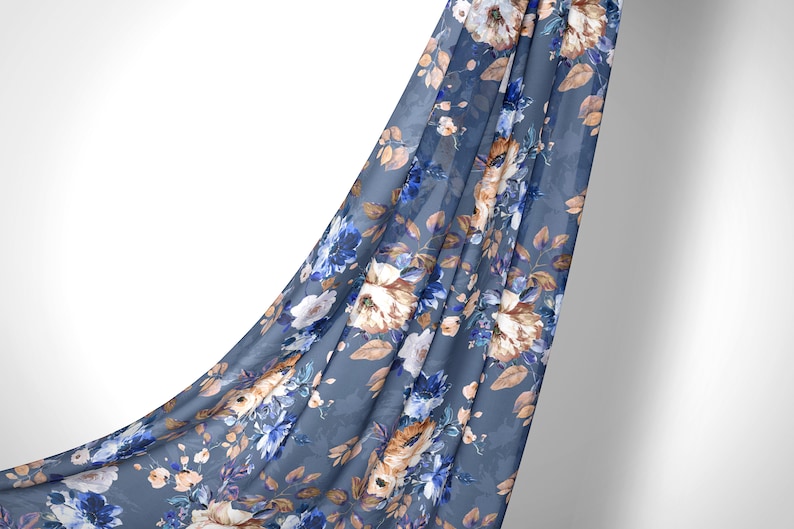 May include: A blue fabric with a floral pattern featuring white, brown, and blue flowers. The fabric is draped over a white background.