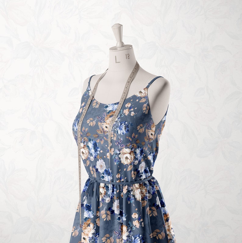 May include: A blue floral print dress with a white background and brown accents. The dress is on a white mannequin with a measuring tape around the neck. The tape reads "L 12".