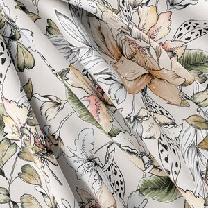 May include: A white fabric with a floral pattern. The flowers are in shades of brown, pink, and green. The fabric has a soft, flowing texture.