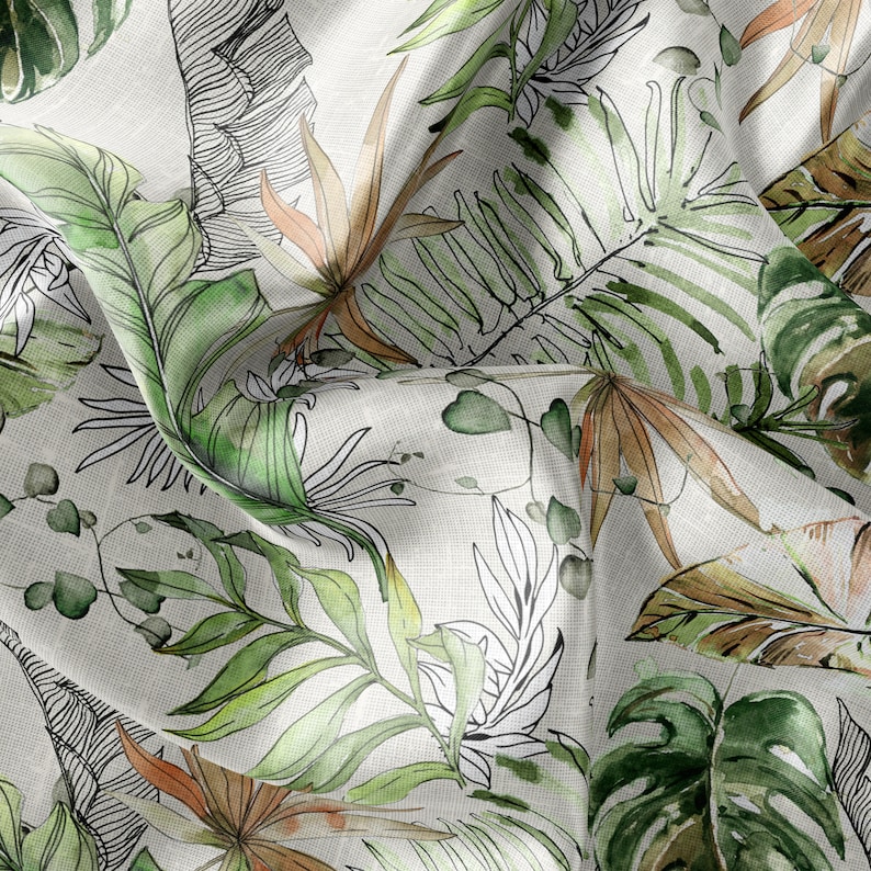 May include: A white fabric with a green and brown tropical leaf pattern. The fabric is wrinkled and has a textured surface.