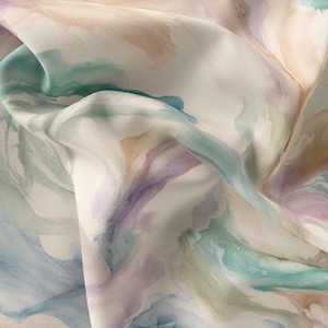 Puede incluir: Tela de impresión de acuarela abstracta en tonos de azul, verde, morado y beige. La tela es suave y fluida, con un brillo sutil.
