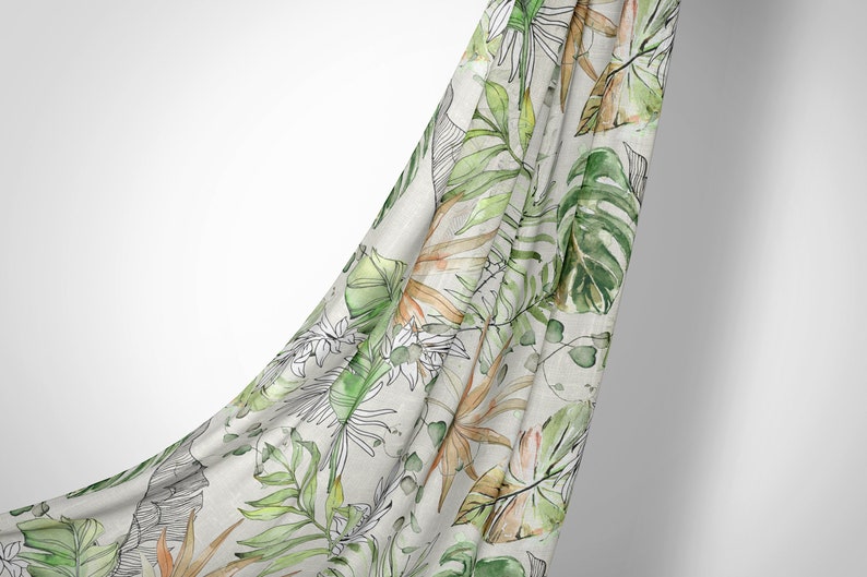 May include: A white fabric with a green and orange tropical leaf pattern. The fabric is draped over a white background.
