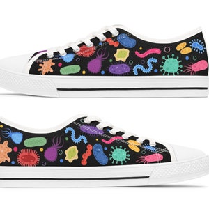 May include: A pair of black canvas shoes with a colorful pattern of various bacteria and microbes. The shoes have white laces and a white sole.