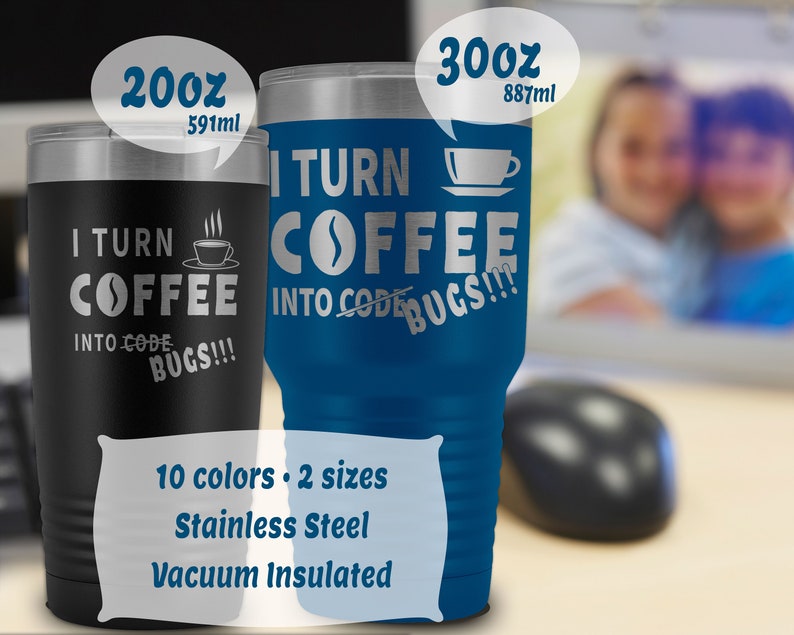 以下が含まれることがあります： 青と黒のステンレス製真空断熱タンブラー2個。タンブラーは20オンスと30オンスで、「I turn coffee into code bugs!」という文字が書かれています。