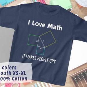 Op de afbeelding: Een marineblauw T-shirt met de tekst "I Love Math" en een geometrisch diagram met de letters "a", "b" en "c". De tekst "IT MAKES PEOPLE CRY" staat onder het diagram. Het T-shirt is verkrijgbaar in 6 kleuren en maten Youth XS-XL. Het is gemaakt van 100% katoen.