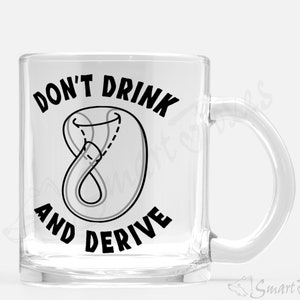 Op de afbeelding: Een heldere glazen mok met een zwart ontwerp dat "Don't drink and derive" zegt met een tekening van een klimmende figuur acht knoop.