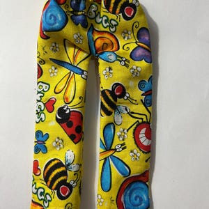 May include: Yellow pants featuring a colorful all-over print of various insects including bees, ladybugs, dragonflies, and snails, along with small white flowers and red hearts. The word Bugs is printed in a stylized font throughout the fabric.