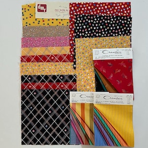 May include: A selection of fabric swatches in diverse patterns and colours. The swatches feature floral, polka dot, plaid, and striped designs. Some swatches have labels from "Crantex" and "d.m.c. textile, inc."