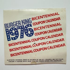 Może przedstawiać: Vintage kalendarz kuponów Burger King Bicentennial z 1976 roku. Projekt przedstawia niebiesko-biały, usiany gwiazdami "1976" z "Burger King" nad nim. Czerwony tekst powtarza "Bicentennial Coupon Calendar" na białym tle. Kalendarz ilustruje wydarzenia historyczne.