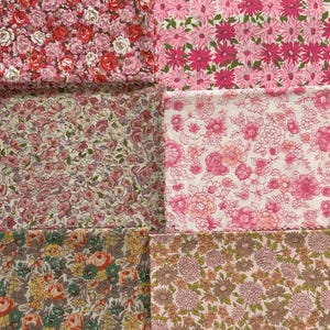 May include: A collection of six fabric swatches featuring floral patterns. The swatches display various pink, red, yellow, and green floral designs. The fabrics showcase different flower types, including roses and daisies, in a variety of sizes and arrangements.