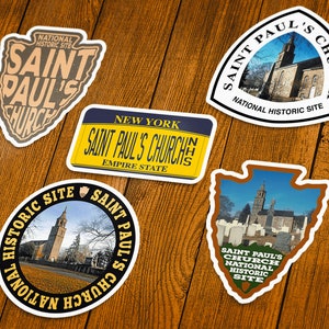 May include: A collection of Saint Paul's Church stickers in various shapes. The stickers feature images of the church and the text "Saint Paul's Church" and "National Historic Site". One sticker is shaped like a New York license plate.