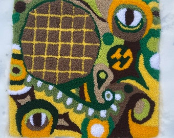 May include: A colorful abstract rug with a brown, yellow, and green pattern. The rug is made of yarn and has a textured surface.