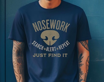 May include: A navy blue t-shirt with a gold graphic of a nose and the text "Nosework Search Alert Repeat Just Find It".