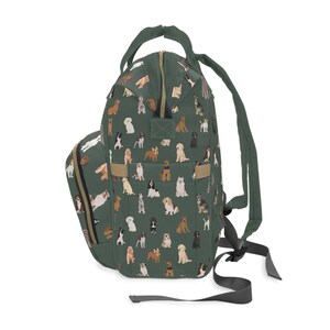 May include: A green backpack with a pattern of various dog breeds. The backpack has adjustable straps and a zippered front pocket.