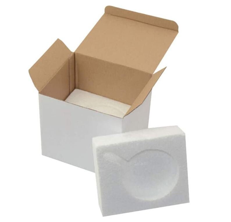 May include: A white cardboard box with a brown cardboard lid is open. The box is lined with white foam packing material. A separate piece of white foam packing material is shown next to the box.
