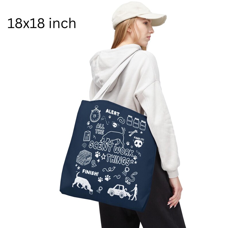 May include: Navy blue tote bag, 18 x 18 inches, with white illustrations and text related to scent work. The text includes "ALERT", "ALL THE", "SCENT WORK THINGS", and "FINISH!". The bag has a white shoulder strap.