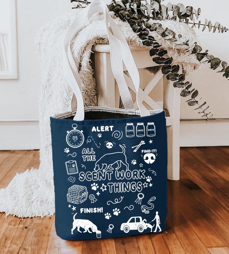 May include: Navy blue tote bag with white handles featuring the text "ALERT ALL THE SCENT WORK THINGS" and dog-themed illustrations. The bag includes images of a dog, paw prints, and a car.