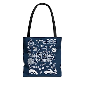 May include: Navy blue tote bag with a black handle. The bag features white illustrations and text, including "ALERT," "ALL THE SCENT WORK THINGS," and "FINISH!" The design includes a dog silhouette, paw prints, and other related icons.