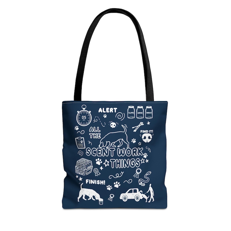 May include: Navy blue tote bag with a black handle. The bag features white illustrations and text, including "ALERT," "ALL THE SCENT WORK THINGS," and "FINISH!" The design includes a dog silhouette, paw prints, and other related icons.
