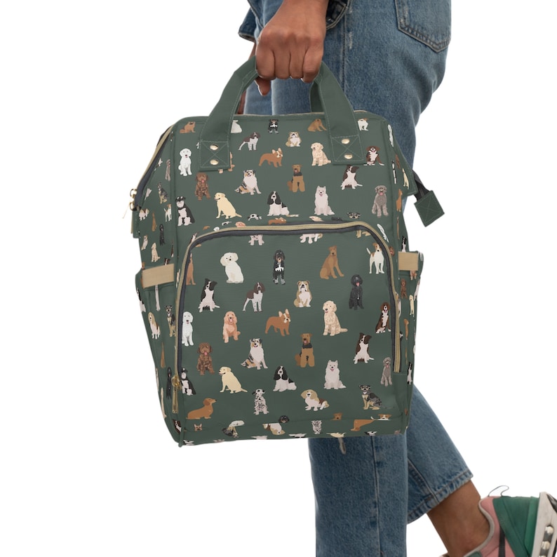 May include: A green canvas backpack with a pattern of various dog breeds. The backpack has a zippered front pocket and adjustable straps.