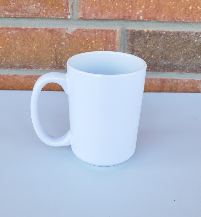 May include: A white ceramic mug with a large handle. The mug is blank and ready to be customized.